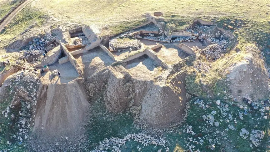Zernaki Tepe’de kazıyla açılmış taş duvarlar, toprak kesitleri ve çevresindeki yamaçların havadan görünümü.
